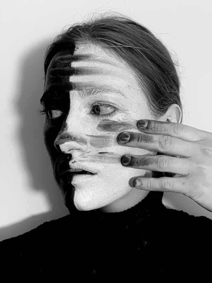 Unique black and white portrait exploring duality and individuality through creative makeup.